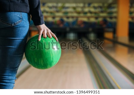 Young woman playing bowling in club