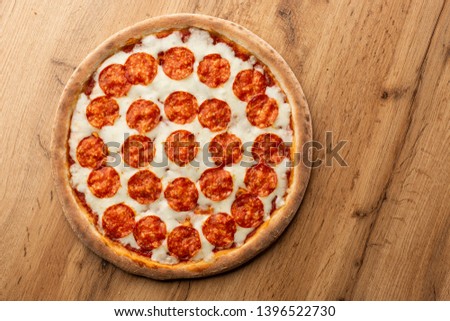 Delicious hot homemade Pepperoni pizza on the wooden table