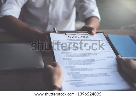 Woman submits job application, Interviewer reading a resume. Royalty-Free Stock Photo #1396524095