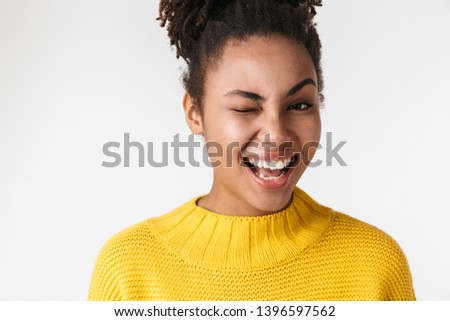 Image of a beautiful young african happy excited emotional woman posing isolated over white wall background winking.