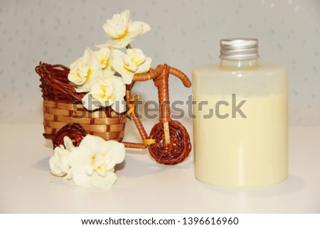 Flowers and jar with body gels, in delicate tones. Massage with natural oils and organic creams. Wicker basket with spring flowers.