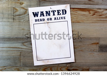 Wanted poster in front of wooden wall with copy space for own picture as a wanted photo