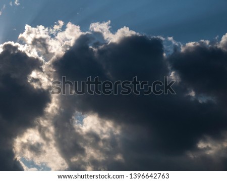 Stormy clouds with the sun, dramatic backdrop of the blue sky with clouds and sun