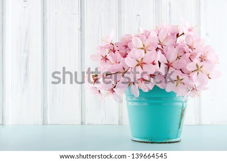 Pink cherry blossom flower bouquet on light blue vintage and white wooden background