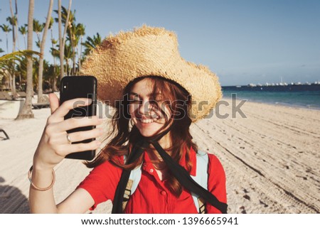    happy woman in selfie hat on the phone on the beach trip                            
