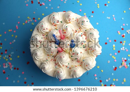 birthday cake with candles for birthday on a blue background with confetti