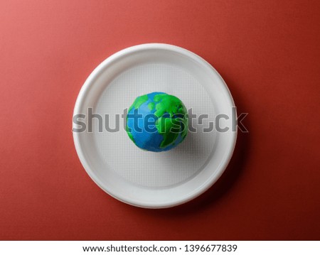 Serving table with Earth planet on plastic plate. Ecology Concept for Earth Hour, Earth Day, Ocean Day and other ECO dates.