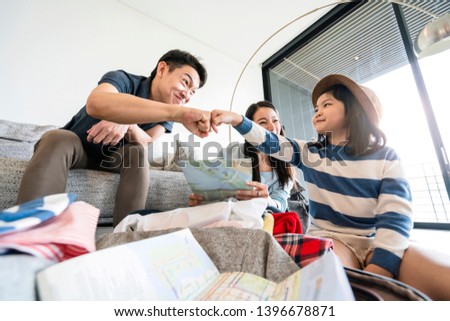 Asian Family travel concept happiness dad mom daughter packing stuff  cloths and planing for vacation road trip with exited and joyful