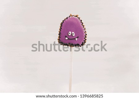 Halloween gingerbread cookies with pictures purple smiling monsters on white background, copyspace. Concept of fun holidays.