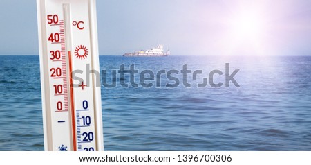 The thermometer on the background of the sea in sunny weather shows 35 degrees of heat. Summer temperature at the resorts