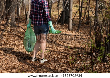 woman picking up dump on dirty forest