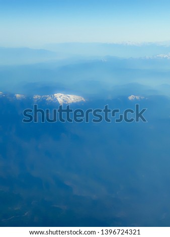 Blurred abstract aerial view of blue sky, clouds, mountain and our planet. Background and texture
