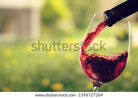 Red wine and glass on background
