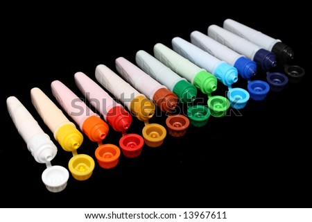 A row of colorful water colors over black background.
