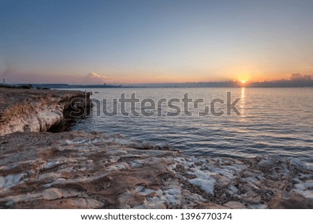 Mediterranean sea at dawn. Beautiful Cypriot landscape with pink and white rocks with an arch in the foreground against a background of pink sky and Golden rising sun.