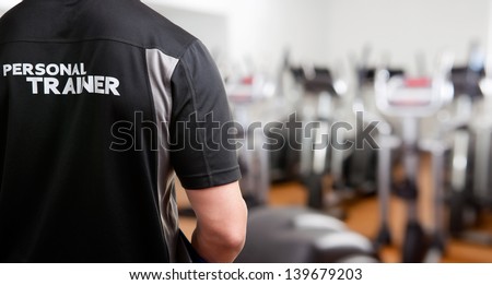 Personal Trainer, with his back facing the camera, looking at a gym Royalty-Free Stock Photo #139679203