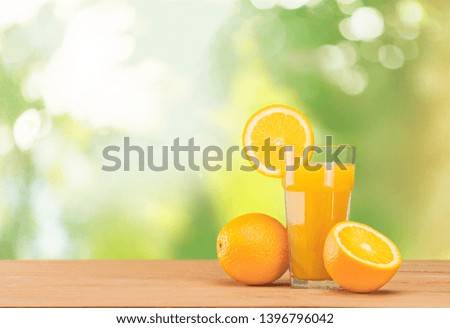 Fresh orange juice on wooden table over grunge background