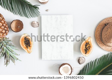 Summer composition. Tropical palm leaves, marble paper blank, hat, coconut, pineapple on pastel gray background. Summer concept. Flat lay, top view, copy space