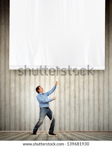 Adult man pulling blank banner. Place for text