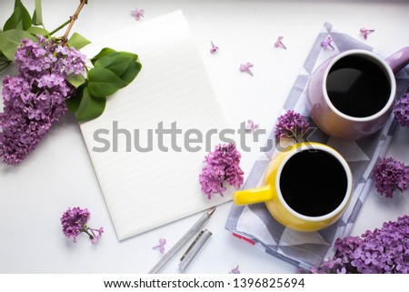 notebook mockup with mug with black coffee with lilac. morning coffee cup, craft envelope, blossom, flat lay, top view
