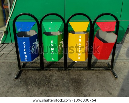 Separate waste collection - four colorful trash cans. Moscow, Russia. Inscriptions mean: glass (blue), paper (green), plastic (yellow).