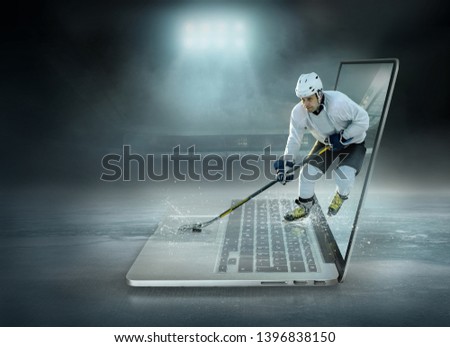 Caucassian ice hockey Player in dynamic action in a professional sport game play on the laptop in hockey under stadium lights.