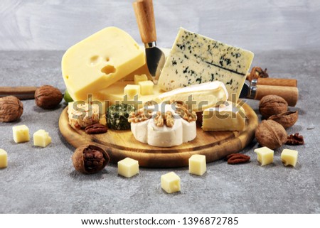 Cheese plate served with figs, various cheese on a platter on wooden table