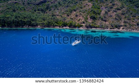 Aerial view of sea and yacht. Sailing ship in the middle of ocean, top view, summer background. Amazing view to Yacht sailing in open sea at sunny day