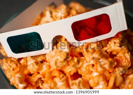 3d paper glasses and cheesy popcorn close up at home
