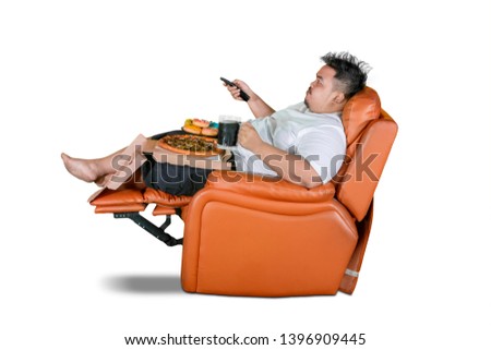 Picture of obese man watching television while enjoying junk foods and cola on the sofa, isolated on white background