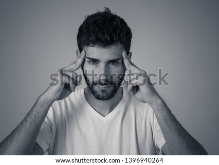 Close up portrait of a young man looking worried and thoughtful suffering from migraines in great pain. Isolated on neutral background. In facial expressions and emotions and heath care concept.