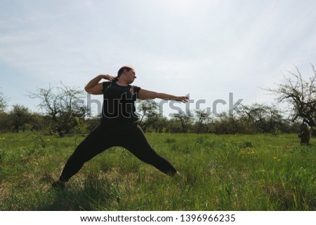 Overweight woman doing yoga in morning park. Healthy lifestyle, sport, weight loss, activity concept