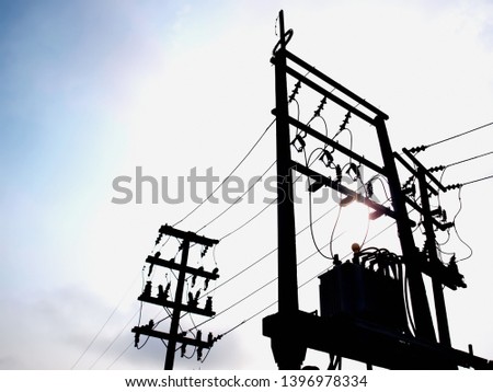 Silhouette of transformers and electrical wires on the pole Three-phase distribution transformer for converting AC power to direct current For retail customers On a white sky background.