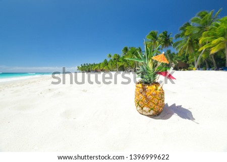 Sweet pineapple cocktail on sand with caribbean beach background. Travel summer vacation banner with copy space for your text