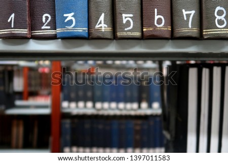 Series of hard cover binding books on library shelf with serial number on each book.Concept of academic student reading / reference researching.