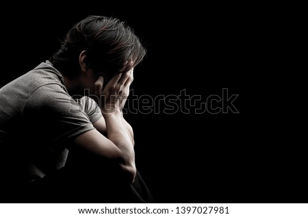 Man sitting alone felling sad worry regret or fear and hand off his face on dark black background Royalty-Free Stock Photo #1397027981