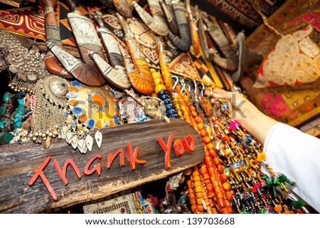 MUSCAT, OMAN - NOVEMBER 13: Words thank you written on board, with hand and jewelery in background. Today, souk in Muscat is one of the most beautiful Arab markets.