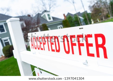 Accepted Offer sign in front of a house for sale. Real estate background concept