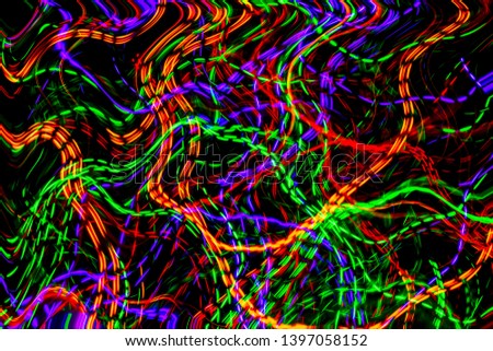 The chaotic lines of color lights on dark background. Colorful lights is move in the black space.