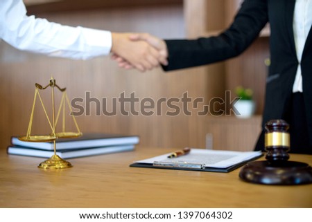 in Law office, Judge woman gavel with Justice lawyers having meeting with team  at law firm in background. Hand shake Concepts of law. 
