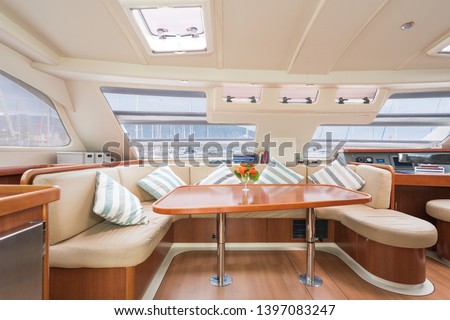 Interior of a stunning modern private sailing catamaran, portraying the saloon with big lounging area with cushions  Royalty-Free Stock Photo #1397083247