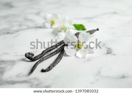 Aromatic vanilla sticks and flowers on marble background