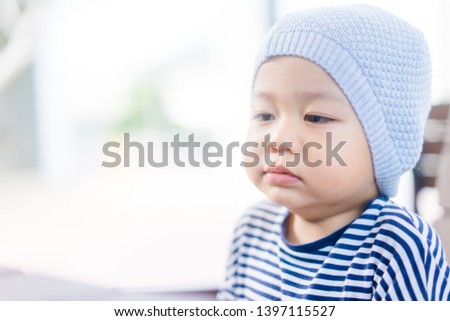 Little asian toddler boy wear hat and yawning in winter time.2 years old boy make sleepy face and tired face.