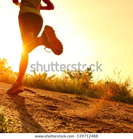 Young lady running on a rural road during sunset Royalty-Free Stock Photo #139712488