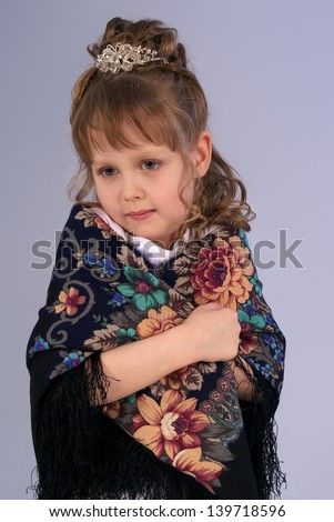 little girl with a tired look on a gray  background