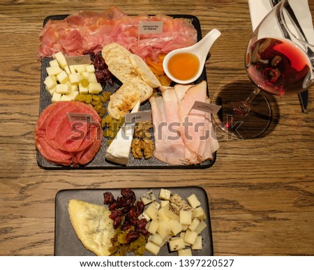 Cured meat and cheese board pairing with wine, a snack made in heaven for some / Charcuterie Board with Wine / After a hearty meal, a perfect choice for Mother's Day celebration