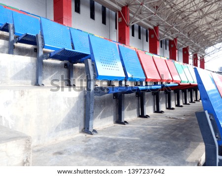 Blue and red iron seats. View of stadium with empty seat. Colorful seat in soccer stadium when holiday. Landscape of free arena seating.  
