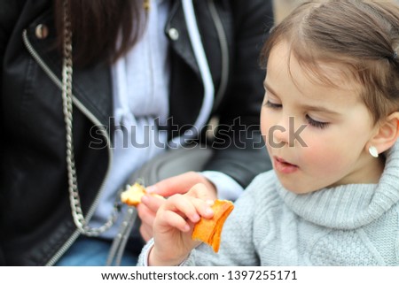 beautiful little cheerful smiling girl with her mother on a walk in the street