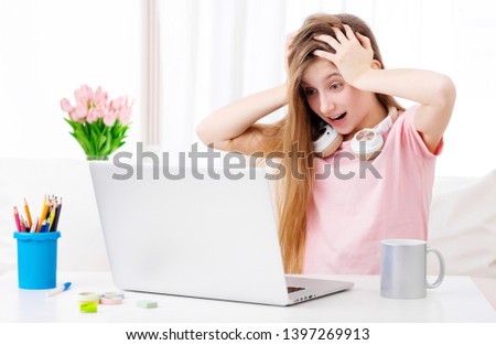 Beatiful girl is amazed about pictures on her personal laptop