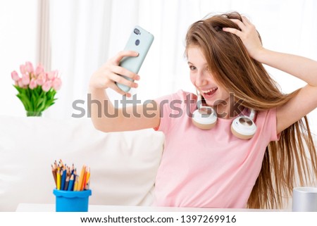 Beatiful teen making selfie of herself in cool headphones on breaks